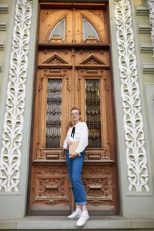 Симпатичная женщина с книгой в руках на открытом воздухе, читает и общается