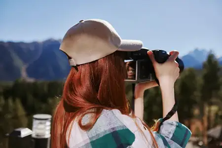 Турист с фотоаппаратом на природе, горный пейзаж, технологии
