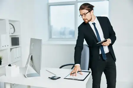 Мужчина в костюме с документами в руках общается по телефону