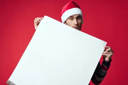 Весёлый мужчина в новогодней одежде рекламирует копировальное пространство на изолированном фоне