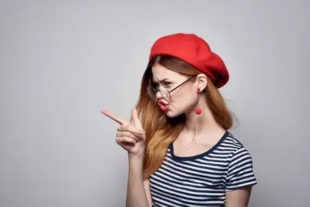 Француженка в очках позирует с привлекательным модным взглядом, на ней красные серьги и украшения
