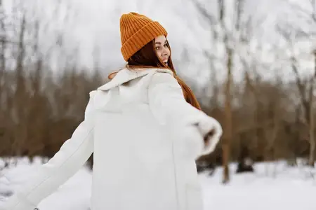 Молодая женщина с рыжими волосами гуляет на свежем зимнем воздухе