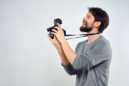 Фотограф-мужчина, профессиональная камера, работа, студия, технологии, современное искусство, светлый фон