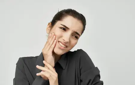 Женщина с недовольным выражением лица, испытывающая зубную боль
