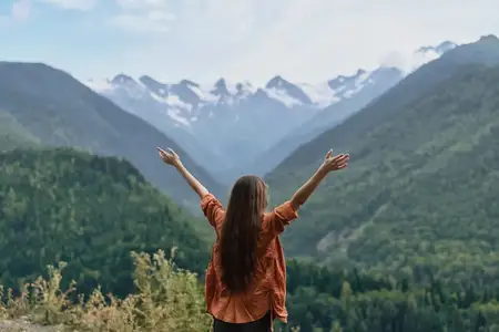 Женщина, горы, природа, отдых на открытом воздухе, приключения, свобода, инклюзивная аутентичная путешественница с поднятыми руками над склонами долины, аутентичность, инклюзивность, мирный…