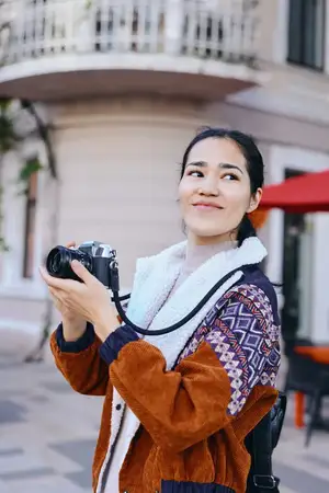 Камера, фотография, женщина на улице, город, образ жизни, улыбка, куртка, шарф — все это передает готовность к путешествию, уличный стиль и повседневный блоггинг, демонстрируя любопытство, баланс и…