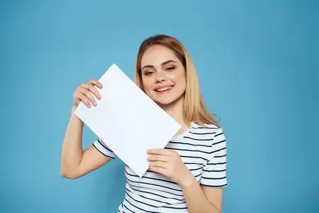 Эмоциональная женщина держит в руках лист бумаги
