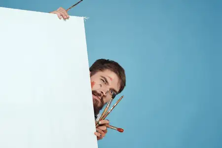 Художник-мужчина стоит спиной за мольбертом, кисть, искусство, творчество, синий фон