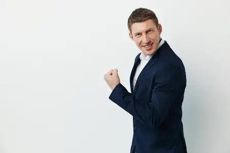 Уверенный в себе мужчина в стильном сером костюме и рубашке демонстрирует положительные эмоции