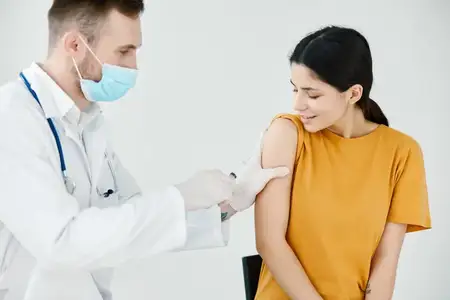 Врач фиксирует инъекцию на плече пациента с помощью лейкопластыря