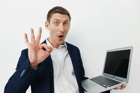 Портрет мужчины с ноутбуком, выражающего удивление