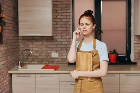 Женщина на кухне в квартире, среди кухонной утвари