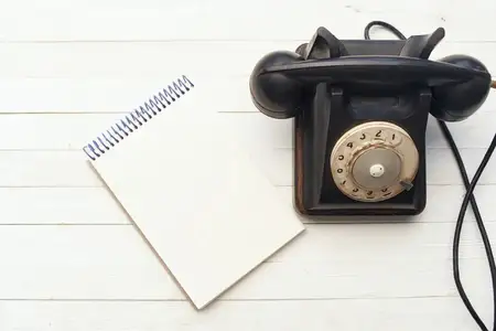 Ретро-телефон, блокнот и деревянный фон создают атмосферу офиса и коммуникации