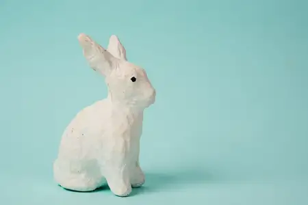 Праздничная игрушка — белый кролик на голубом фоне в пастельных тонах, Пасха