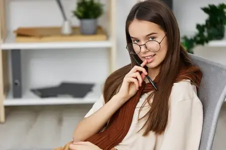 Молодая женщина сидит в кресле в помещении, похожем на офис