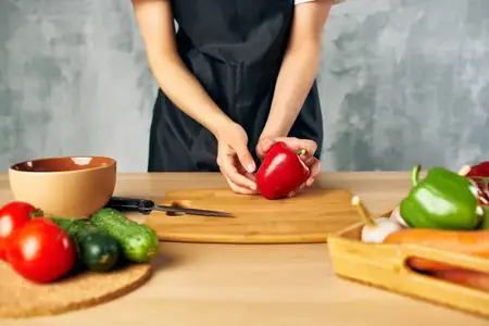 Домохозяйка на кухне нарезает овощи для салата, диетическое питание