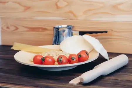 Помидоры черри, паста, кухонная утварь, деревянный стол, итальянская кухня