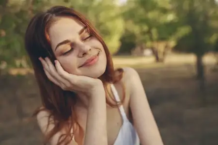 Крупный план женщины в белом платье, которая ест виноград