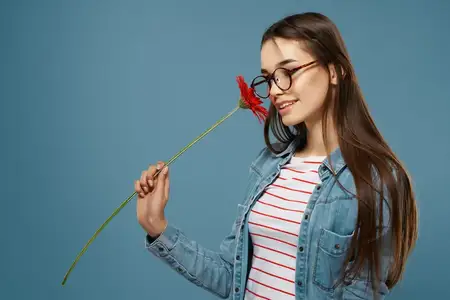 Женщина в очках, рядом с лицом красный цветок, мода, студийная съёмка