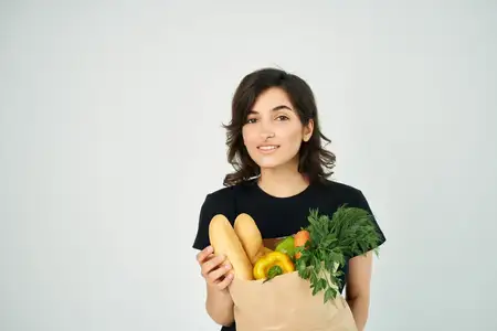 Брюнетка в черной футболке с пакетом продуктов, овощи в супермаркете
