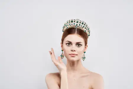 Портрет женщины с короной на голове, с макияжем, на изолированном фоне