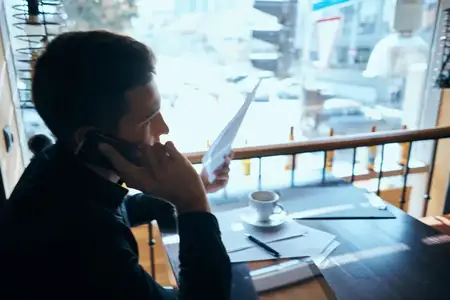 Бизнесмен-фрилансер работает в кафе за ноутбуком