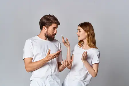 Молодая пара в наушниках слушает музыку, испытывая яркие эмоции и веселье