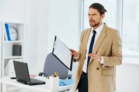 Мужчина в бежевом пиджаке работает с официальными документами в офисе