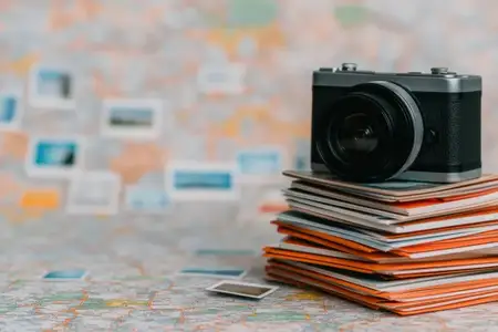Винтажная камера, расположенная на стопке красочных фотоотпечатков на размытом фоне