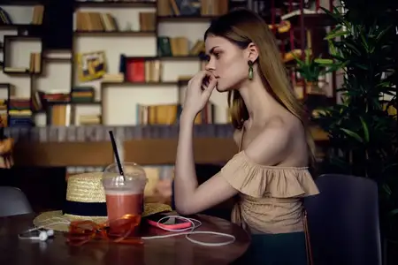 Весёлая женщина с книгой в руках общается в кафе