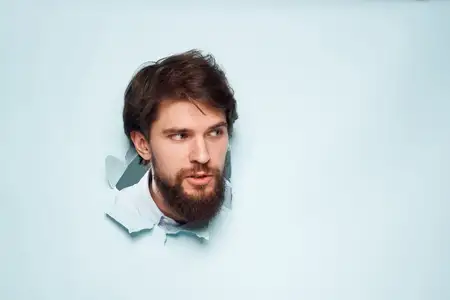 Мужская голова выглядывает из-за стены, символизирующей эмоции, недовольство работой и карьерой
