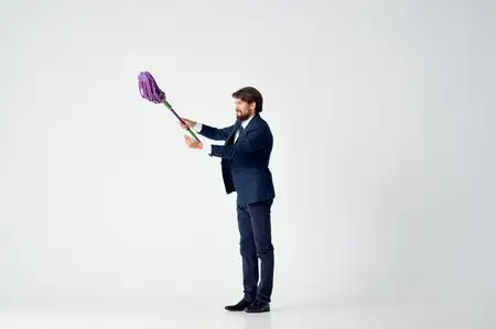 Деловой мужчина в костюме, менеджер, работающий с уборкой шваброй
