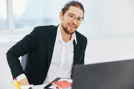 Менеджер работает с документами в офисе за ноутбуком
