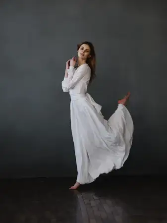 Женщина в роскошном белом платье позирует для модной фотосессии
