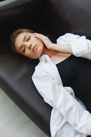 Женщина лежит дома на диване