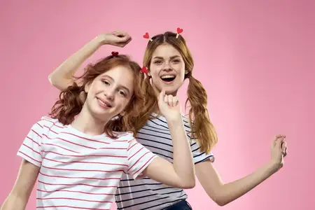 Забавные подружки с прищепками в волосах на розовом фоне