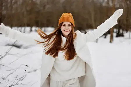 Женщина в зимней одежде и шапке на фоне весёлого зимнего пейзажа