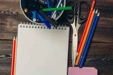 Блокноты, канцелярские принадлежности, карандаши на деревянном столе, офис, бизнес, рисование, школа