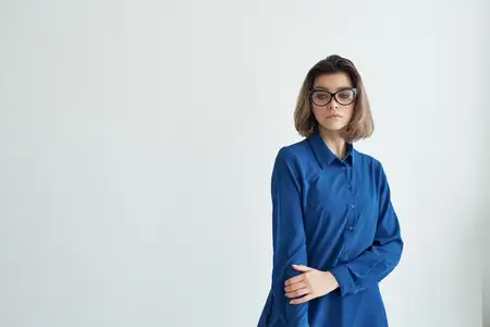 Женщина в очках и голубой рубашке, модная поза, элегантный стиль