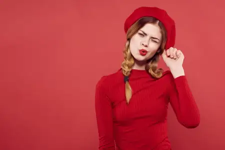 Весёлая женщина в красной кепке на голове, гламурный изолированный фон