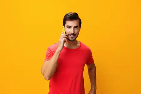 Мужчина со смартфоном, портрет, бизнес, в очках, указывает, образ жизни, удивлён, сообщение, счастливый, технологии, общение, жёлтый фон, студия, улыбается