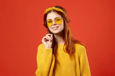 Привлекательная женщина в желтом свитере и очках