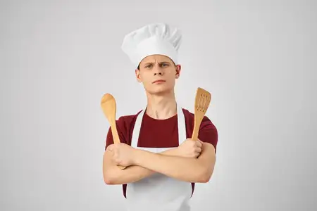 Мужчина в униформе повара готовит на кухне, запечатлён в стиле жизни