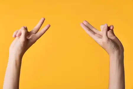 Крупный план жеста руки, показывающей знак мира, на теплом желтом фоне, чтобы предположить единство, оптимизм и дружественный брендинг через четкую, минималистичную композицию и яркое настроение