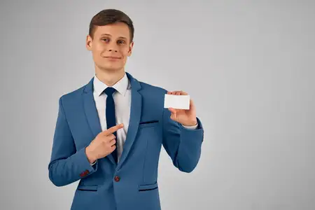 Деловой мужчина в костюме держит визитную карточку