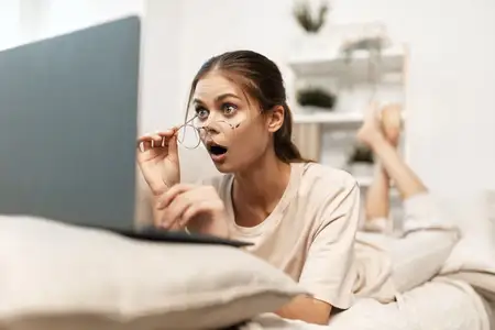 Улыбающаяся женщина работает за ноутбуком в уютном домашнем офисе