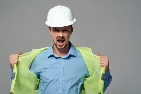 Мужчина в строительной униформе на светлом фоне