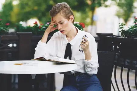 Женщина читает книгу за столиком в ресторане