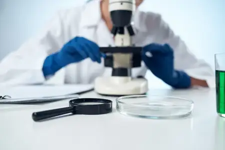 Женщина-ученый работает в лаборатории с микроскопом, занимаясь исследованиями в области биотехнологий