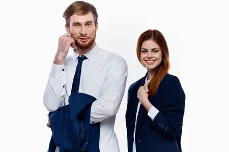 Мужчина и женщина в деловых костюмах стоят рядом с коллегами по работе в финансовом офисе на светлом фоне